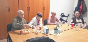 Tři členky a jeden člen SONS sedí u stolu před promítáním