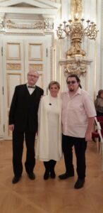 Dva členové a jedna členka SONS uprostřed pózují ve Španělském sále
