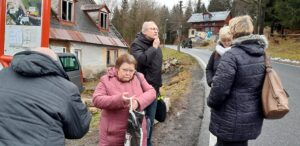 Pětičlenná skupinka členek a členů SONS na zastávce MHD v Rudolfově
