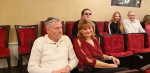 Skupinka členů SONS sedící v hledišti divadla