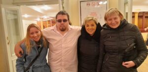 Tři členky a jeden člen SONS pózují ve foajé divadla