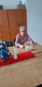 Členka SONS sedí u stolu s občerstvením před zahájením promítání