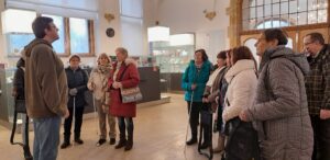 Skupina členek a členů SONS poslouchají výklad průvodce
