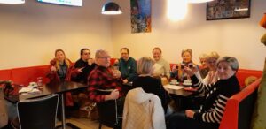 Skupina členek a členů SONS v restauraci připíjejí na památku Endyho (vodicí pes) (