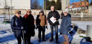 Tři členky a dva členové SONS pózují u vstupu do Zahrady vzpomínek