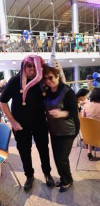 Členka a člen SONS pózují v kloboucích z fotokoutku