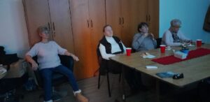 Čtyři členky SONS naslouchají bedlivě ději filmu s audiopopisem